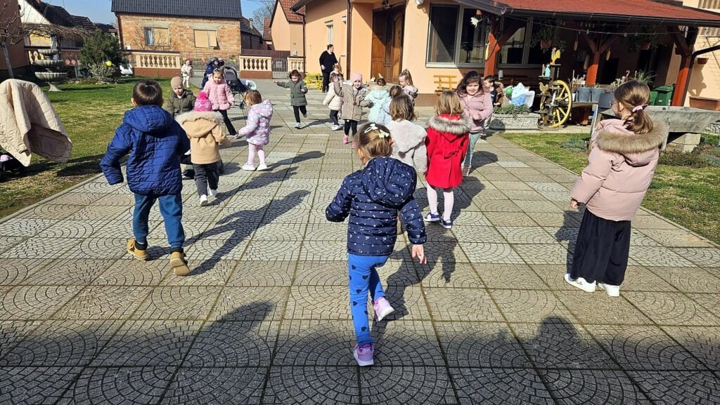 Djeca u šetnji kroz selo, snimljena s leđa