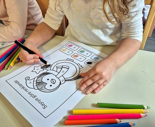 Predškolka bojicama rješava radni listić